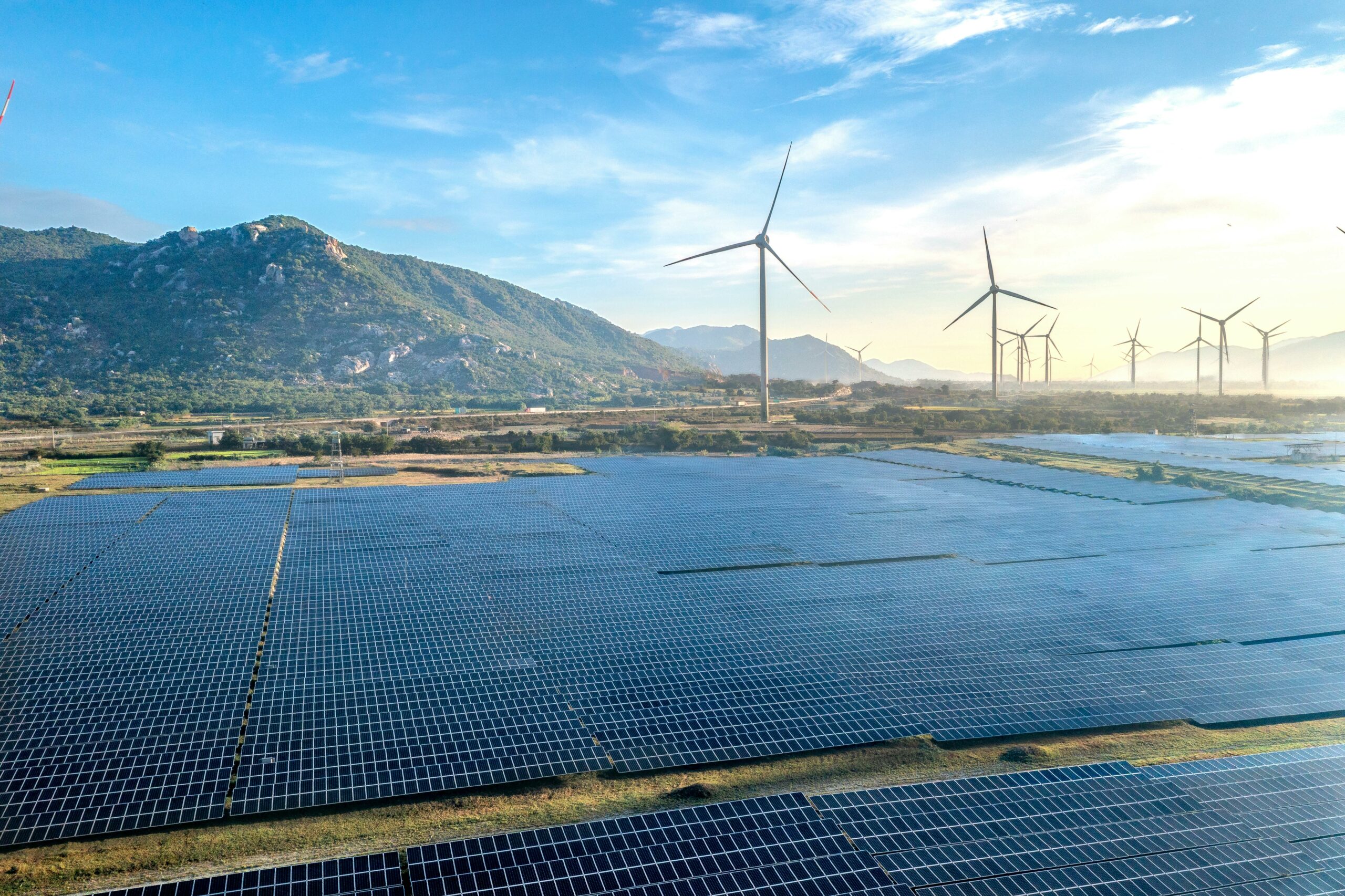 Aerial view of a solar and wind energy farm set against Vietnam's scenic landscape.